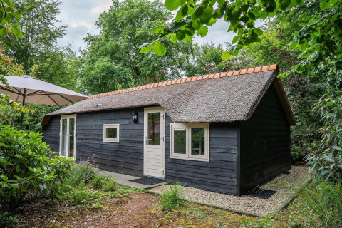 Heivlinder Comfort 4+2p. lodge met rieten dak, zwarte wandbekleding, sfeervol in het groen gelegen.