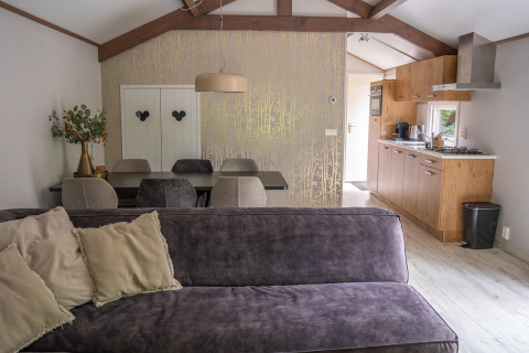 Lichte en moderne woonkamer en keuken in Heivlinder Comfort 4+2p lodge in Nederland, stijlvol ingericht.