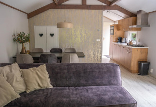 Lichte en moderne woonkamer en keuken in Heivlinder Comfort 4+2p lodge in Nederland, stijlvol ingericht.