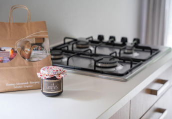 Modern kitchen counter with gas stove, paper bag, and jam jar at Heivlinder Comfort 4+2p in the Netherlands.