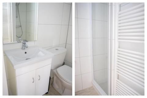 Moderne, lichte badkamer met lavabo, toilet, douche en handdoekradiator in Heivlinder Comfort 4+2p lodge Nederland.