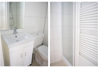Moderne, lichte badkamer met lavabo, toilet, douche en handdoekradiator in Heivlinder Comfort 4+2p lodge Nederland.
