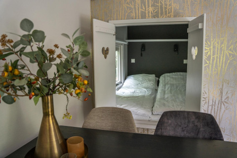 Interieurfoto van Heivlinder Comfort 4+2p lodge in Nederland met gezellige slaaphoek en eettafel.