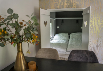 Interior photo of Heivlinder Comfort 4+2p lodge in the Netherlands showing cozy sleeping nook and dining table.
