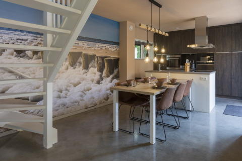 Modern dining area and kitchen in a beach house, large ocean mural, Noordzee Resort Vlissingen, Netherlands.
