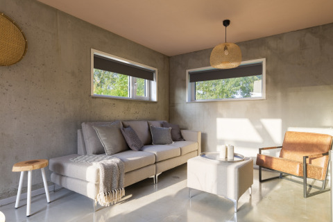 Bright modern living room in 'Noordzee' Resort Vlissingen 3 beach house, Netherlands, with sofa and chair.