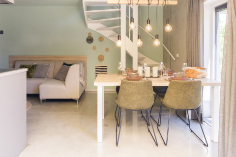 Modernes Wohn- und Esszimmer mit Wendeltreppe im Noordzee Resort Vlissingen 2 in den Niederlanden.