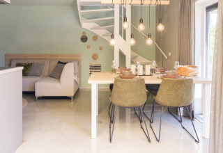 Modernes Wohn- und Esszimmer mit Wendeltreppe im Noordzee Resort Vlissingen 2 in den Niederlanden.