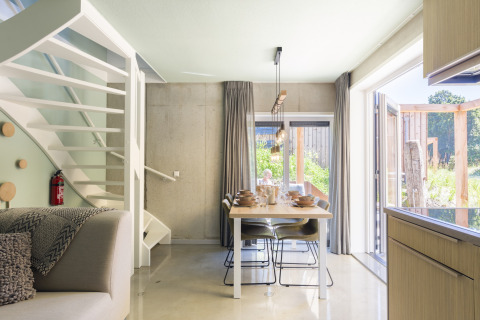 Helles, modernes Esszimmer im Strandhaus Noordzee Resort Vlissingen 2, Niederlande, mit Blick nach draußen.