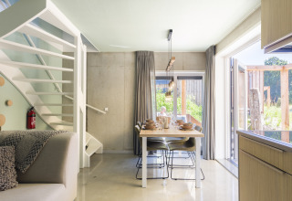 Helles, modernes Esszimmer im Strandhaus Noordzee Resort Vlissingen 2, Niederlande, mit Blick nach draußen.