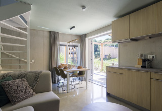 Modernes Wohn- und Esszimmer im Strandhaus «Noordzee» Resort Vlissingen 2 mit Gartenblick in Holland.