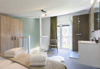Modernes Schlafzimmer mit eigenem Bad und Dusche im Noordzee Resort Vlissingen, Niederlande.