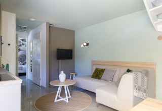 Wohnzimmer im Strandhaus Noordzee Resort Vlissingen 2, Niederlande, mit Sofa, Tisch und Dekor.