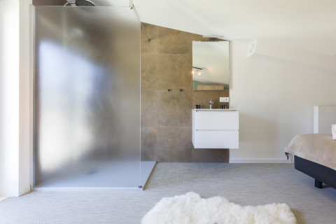 Modernes Badezimmer im Strandhaus des Resort Vlissingen mit Glasdusche, Waschbecken und hellem Interieur.