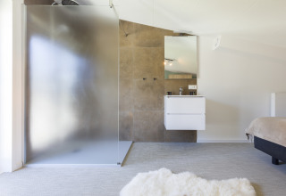 Modernes Badezimmer im Strandhaus des Resort Vlissingen mit Glasdusche, Waschbecken und hellem Interieur.