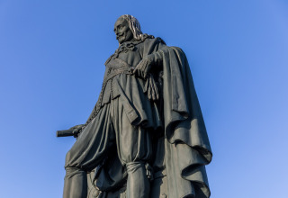 Statue einer historischen Figur im klassischen Gewand vor blauem Himmel am Noordzee Resort Vlissingen.