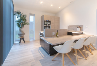Zona pranzo e cucina luminosa e moderna al Water Resort Oosterschelde 13, nei Paesi Bassi, con arredamento elegante.