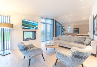 Soggiorno moderno a Water Resort Oosterschelde 13 con grandi finestre, mobili eleganti e cucina a vista, Paesi Bassi.