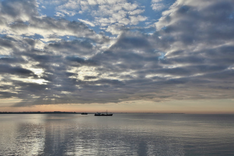 Vista sul mare calmo con barche e nuvole suggestive al Water Resort Oosterschelde 13, Paesi Bassi.