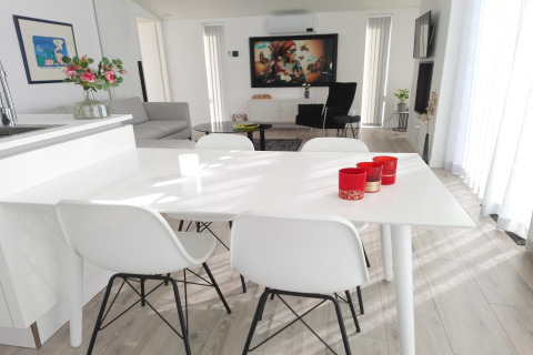 Moderne og lys stue på Water Resort Oosterschelde 46 med hvidt spisebord og elegant indretning.