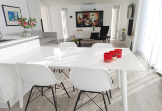 Moderne og lys stue på Water Resort Oosterschelde 46 med hvidt spisebord og elegant indretning.
