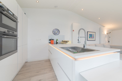 Moderne hvidt køkken med indbygget ovn, køkkenø og elegant vask, Water Resort Oosterschelde 46, Holland.
