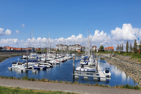 Vista sul porto turistico di Water Resort Oosterschelde 13 in Olanda, barche ormeggiate e cielo azzurro.