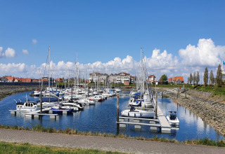 Vista sul porto turistico di Water Resort Oosterschelde 13 in Olanda, barche ormeggiate e cielo azzurro.