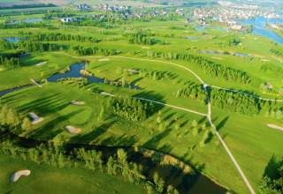 Vista aerea di un campo da golf panoramico con bunker di sabbia e laghetti vicino a Water Resort Oosterschelde, Paesi Bassi.