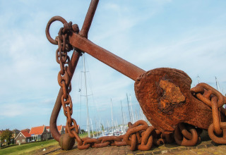 Grande ancora arrugginita con catena vicino a un porto turistico al Water Resort Oosterschelde 13, Paesi Bassi.