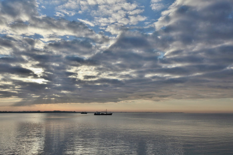 Skyet morgenscene ved stranden og både, set fra Water Resort Oosterschelde 46 i Holland.