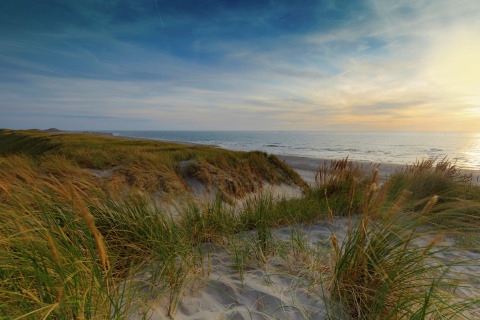 Udsigt over sandklitter og havet ved solnedgang fra Water Resort Oosterschelde 46 i Holland.