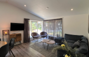Bright living room in Hackfort lodge, Kaatsheuvel, Netherlands, featuring modern furniture and large windows.