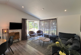 Bright living room in Hackfort lodge, Kaatsheuvel, Netherlands, featuring modern furniture and large windows.