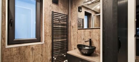 Modern bathroom with black sink and towel radiator in the Hackfort lodge, Kaatsheuvel, Netherlands.