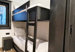 Cozy room at Hackfort lodge in Kaatsheuvel, Netherlands, with bunk bed, dark wardrobe and a small window.