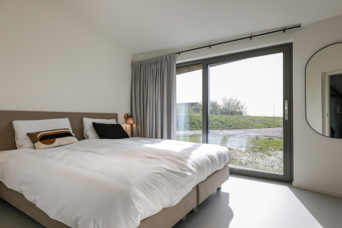 Moderne lodge soveværelse med dobbeltseng, stort vindue og udsigt, Heerlijkheid Vlietenburg 1, Holland.