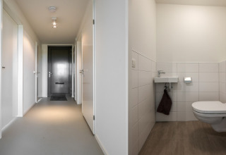 Lys gang og moderne badeværelse på lodge Heerlijkheid Vlietenburg 1 i Holland, med minimalistisk design.