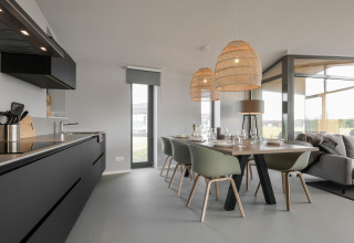 Moderne spisestue og køkken i Heerlijkheid Vlietenburg 1, stilfuldt indrettet med store vinduer.