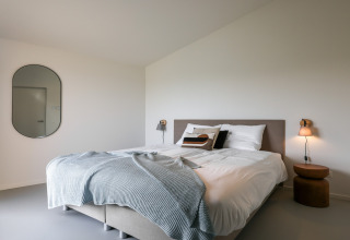 Moderne soveværelse på Heerlijkheid Vlietenburg 1 i Holland med dobbeltseng, tæppe og minimalistisk indretning.