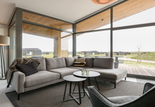 Moderne lodge-stue med store vinduer i Heerlijkheid Vlietenburg 1, med udsigt over naturen i Holland.