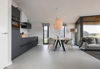 Moderne spisestue og køkken i lodge Heerlijkheid Vlietenburg 1, med store vinduer og naturligt lys.
