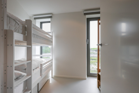 Lyst værelse med køjeseng og store vinduer på Heerlijkheid Vlietenburg 1 lodge i Holland.
