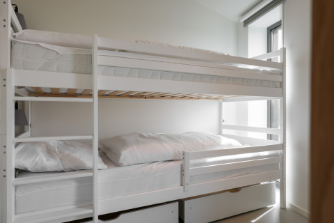 Hvide køjesenge med sengetøj på Heerlijkheid Vlietenburg 1 lodge i Holland, moderne og lyst værelse.