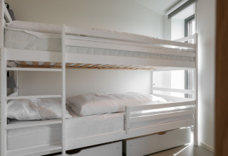 Hvide køjesenge med sengetøj på Heerlijkheid Vlietenburg 1 lodge i Holland, moderne og lyst værelse.