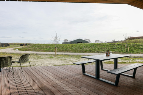 Udsigt fra en træterrasse med bord/bænksæt ved Heerlijkheid Vlietenburg 1 lodge i Holland.