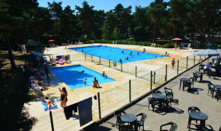 Buitenzwembad van Camping GT Keiheuvel in Antwerpen met mensen die zwemmen en ontspannen aan het water.