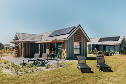 Udendørsbillede af Beach Resort Nieuwvliet-Bad 16 med liggestole og solpaneler på taget.