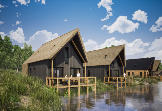 Lodge con tetto in paglia sul lungolago al Resort Nieuwvliet-Bad 13 sotto un cielo azzurro parzialmente nuvoloso.