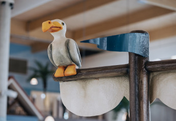 Figura de una gaviota divertida posada en un cartel interior de un alojamiento glamping decorativo.